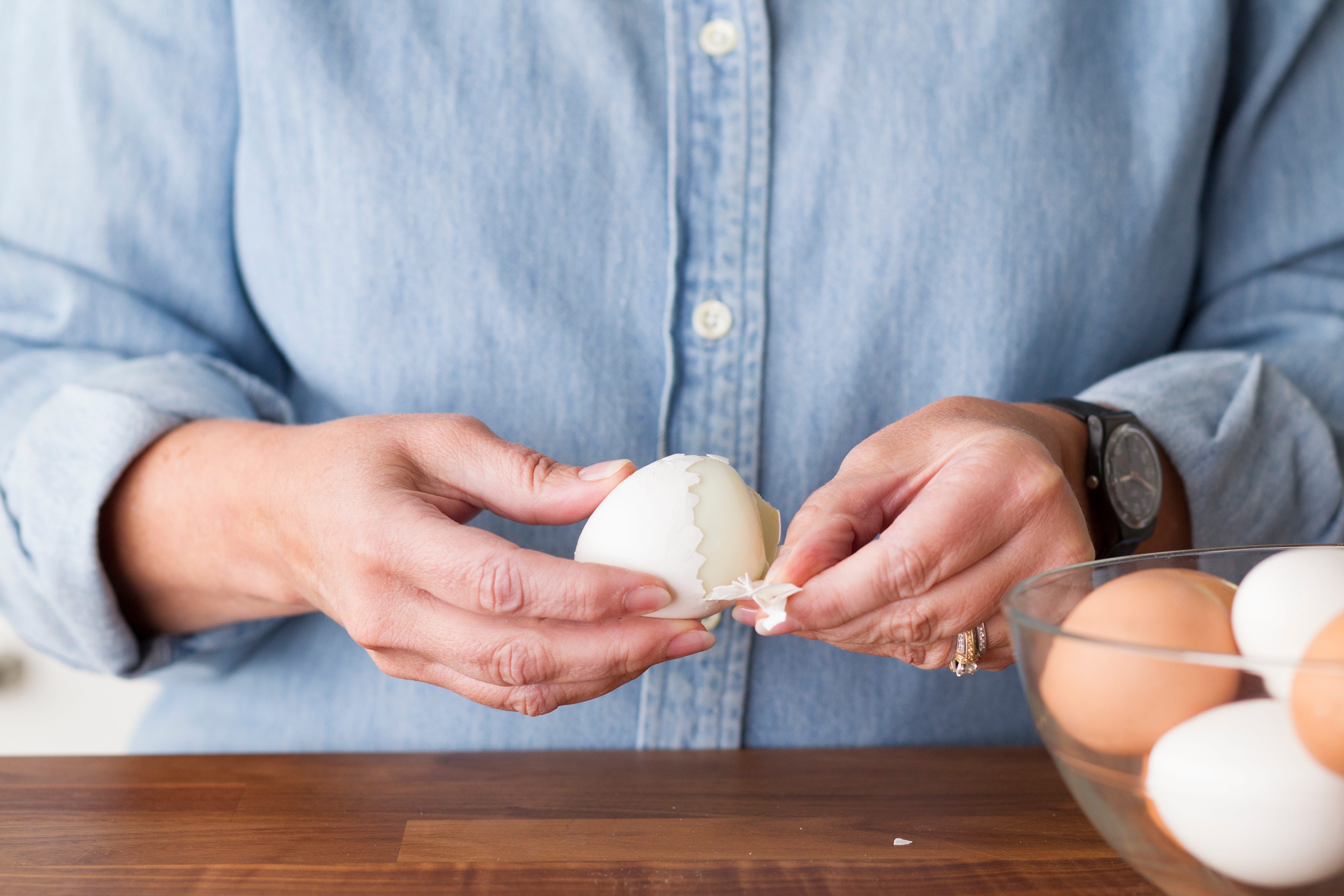 Person showing how to peel a hard boiled egg