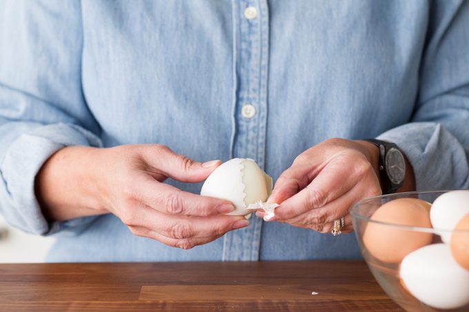 Person showing how to peel a hard boiled egg