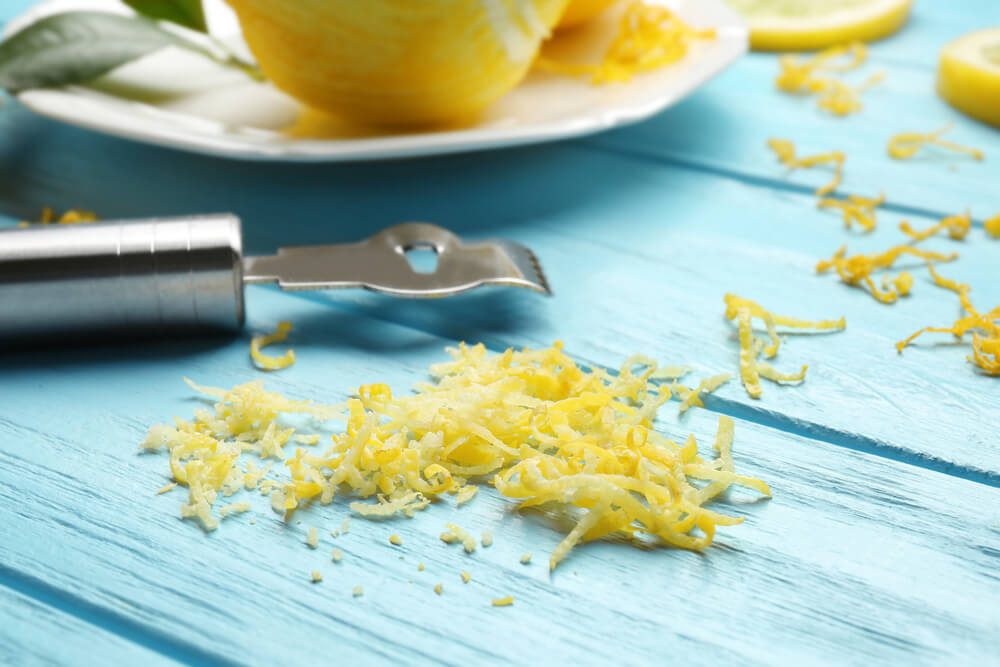 Lemon zest and special tool on wooden table