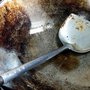 Used dirty iron pan with oil and dirty turner