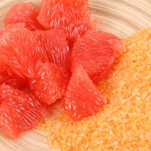 Bowl of grapefruit bath salt and some fresh fruits;