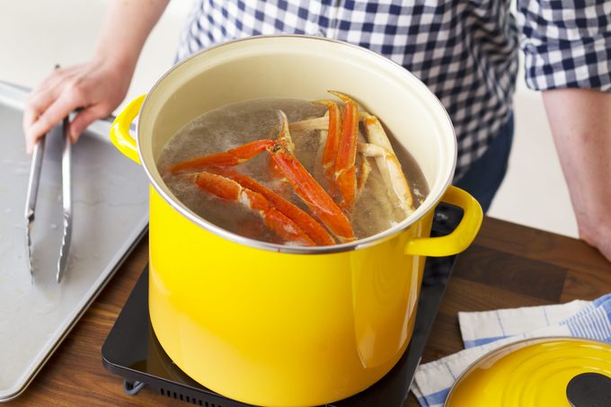 Crab legs boiling in a bright yellow pot