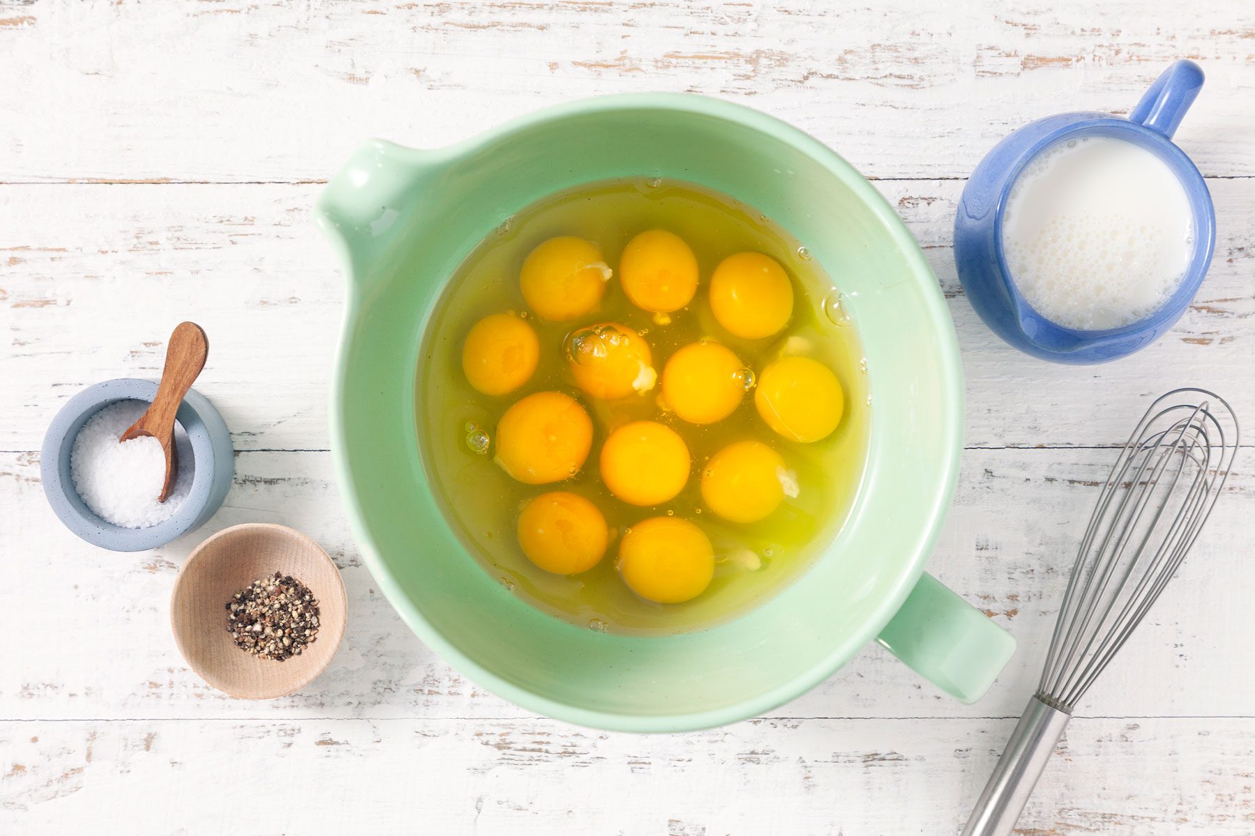 Eggs milk, salt and pepper on a table
