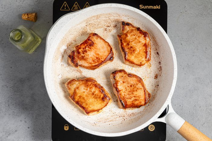 Sautéing Pork Chops In A White Non Stick Skillet on Induction Cooktop