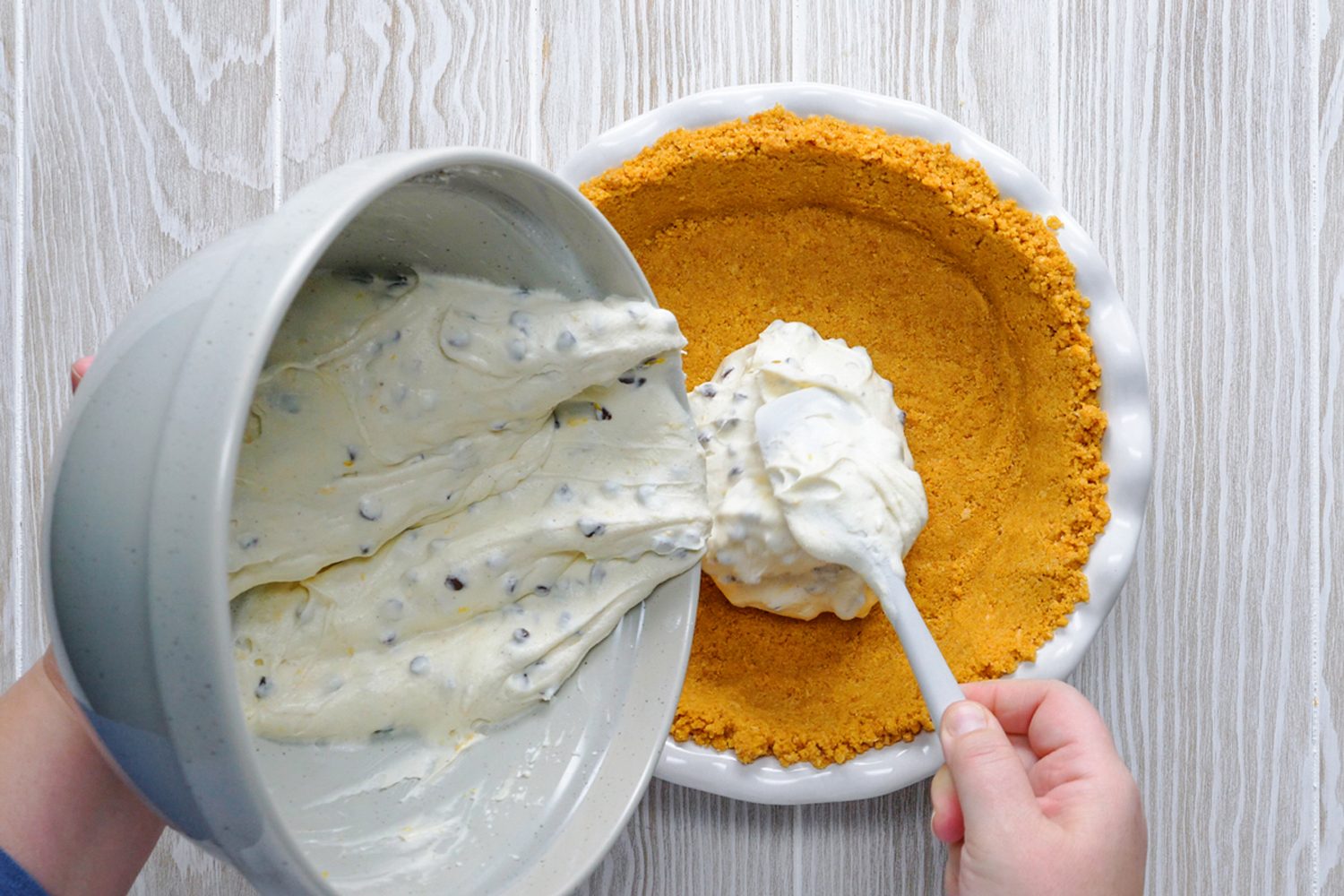 Chocolate chips is spread in crubs of Cannoli shells from a large bowl