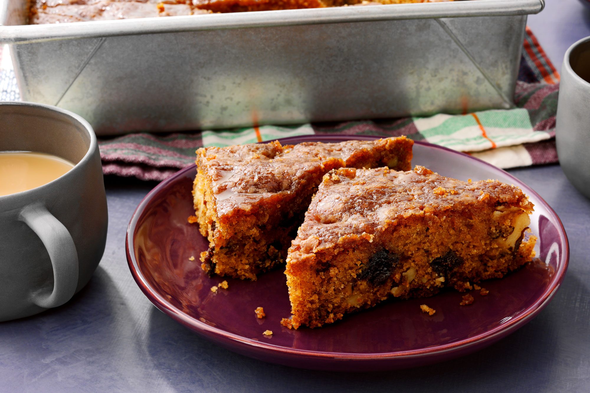 Prune Cake With Glaze slices in a plate with a cup of tea