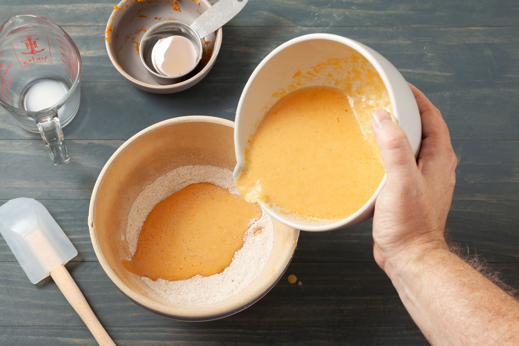 A Person Pouring a Mixture Into a Bowl