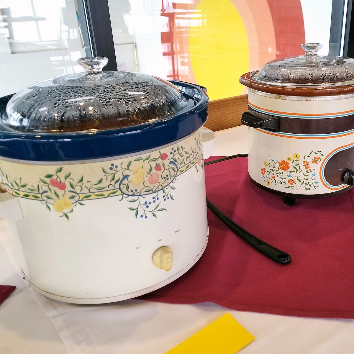 Row of vintage Crock-Pots on table.