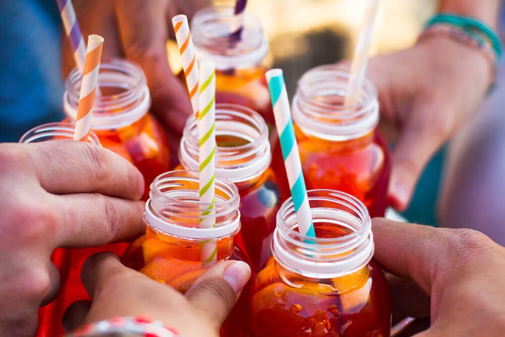 Picnic theme: group of friends holding drinks, toast , close-up