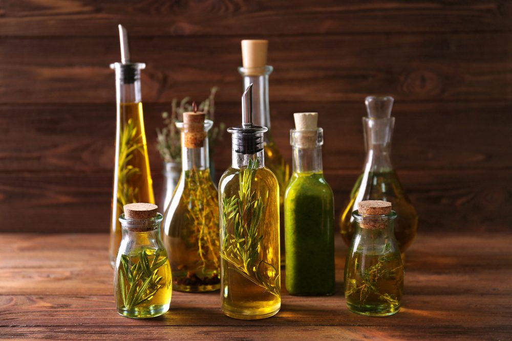 Composition of bottles with oil on wooden background. Keto diet-friendly oils.
