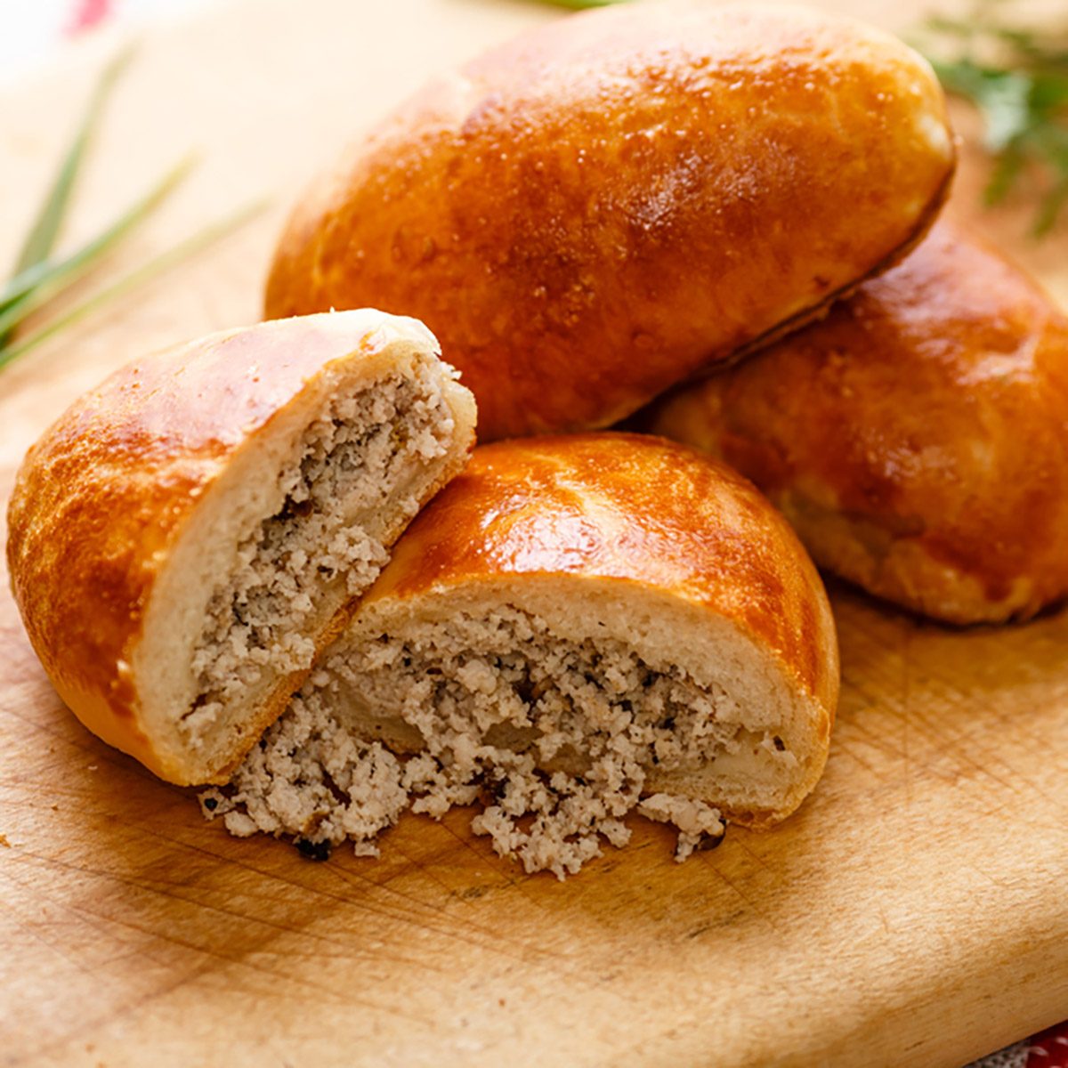 Russian pirozhki (baked patties) on wooden cutboard