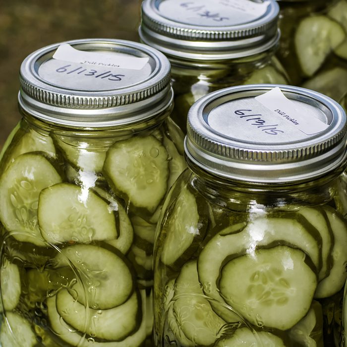 Homemade dill pickles canned in glass jars on display at a farmer