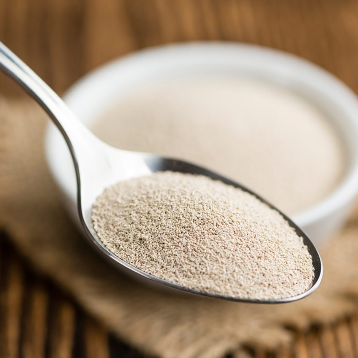 Portion of dried Yeast (close-up shot) on wooden background
