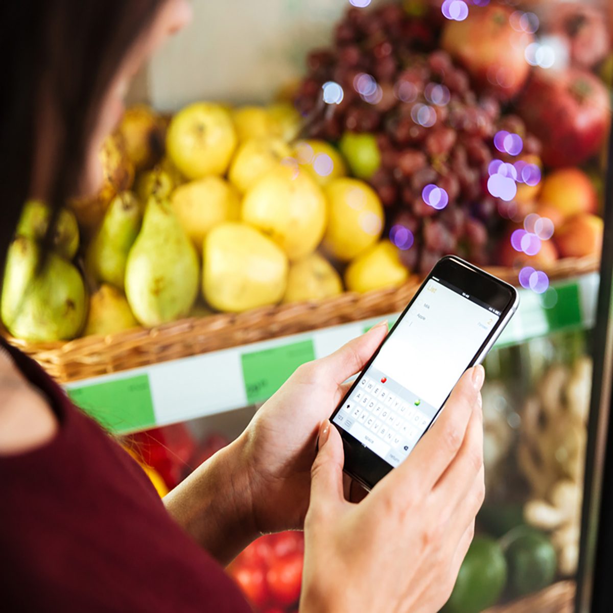 Closeup of woman using cell phone in grocery store