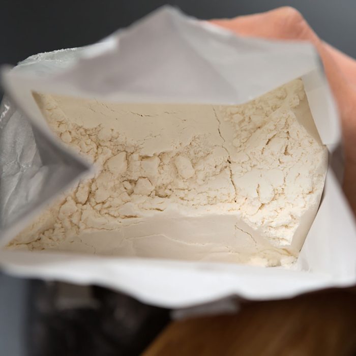 Top View Of Hand Holding Open Bag Of Flour