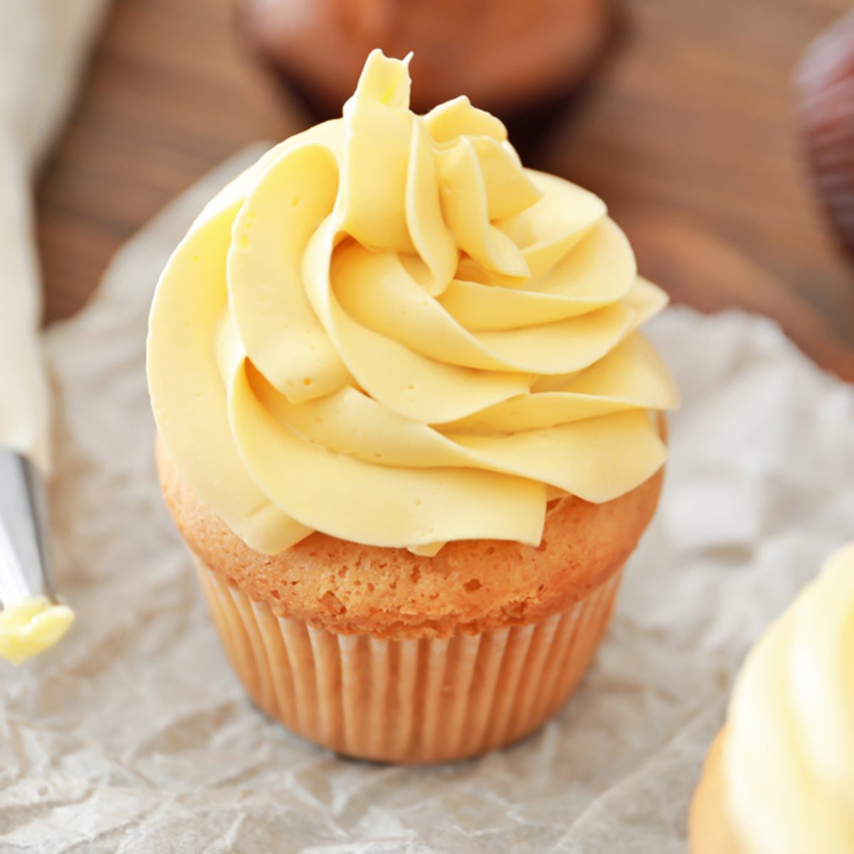 Tasty cupcake with cream on table