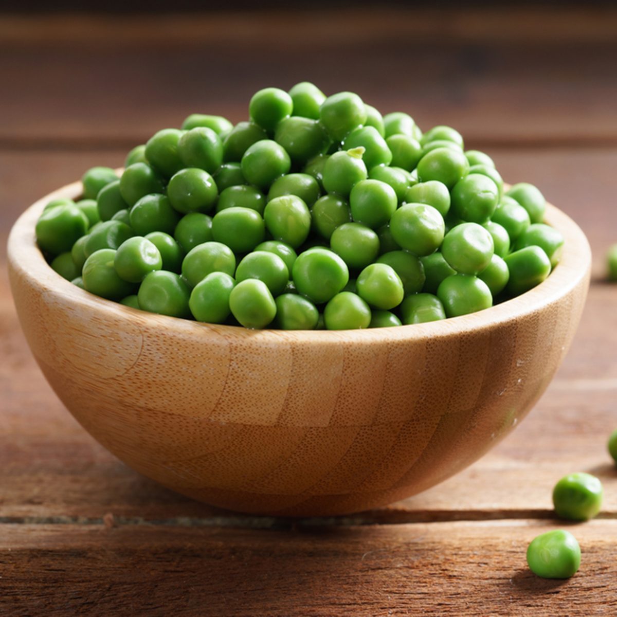 fresh green pea in bowl on wooden background