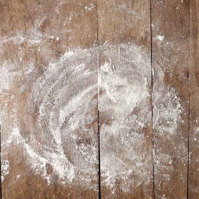white flour on rustic wooden table, top view