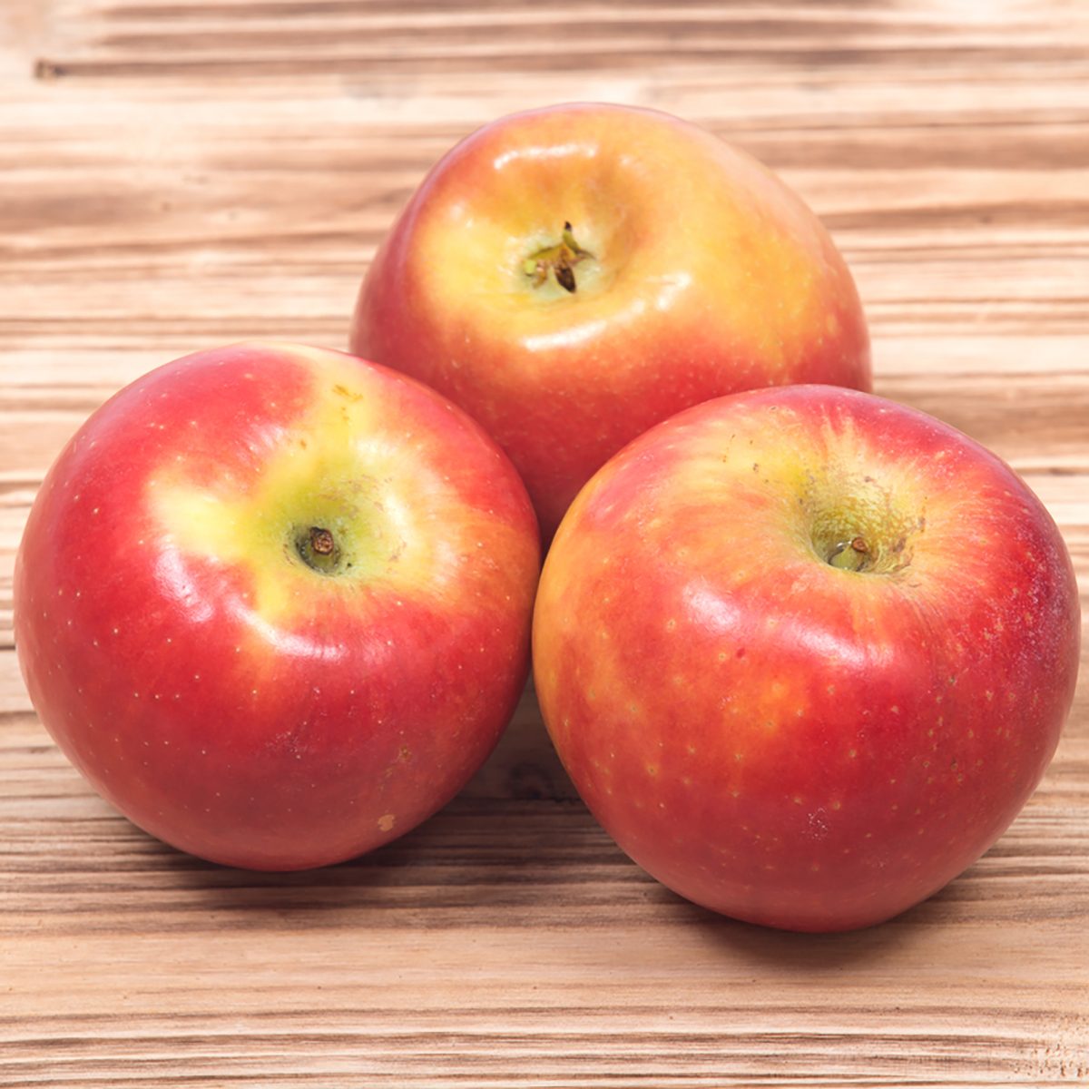 Ripe organic kanzi apple on vintage wooden tray