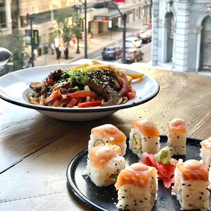 Close-up of a noodle dish and sushi at Latinicity