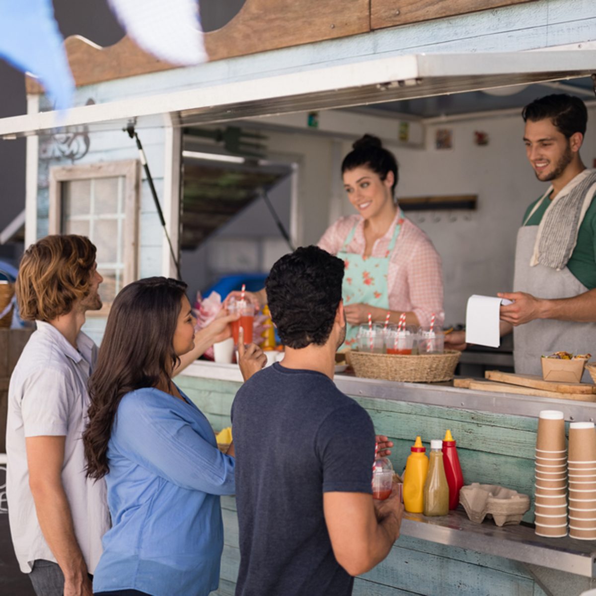 Smiling waiter taking order from customer at counter