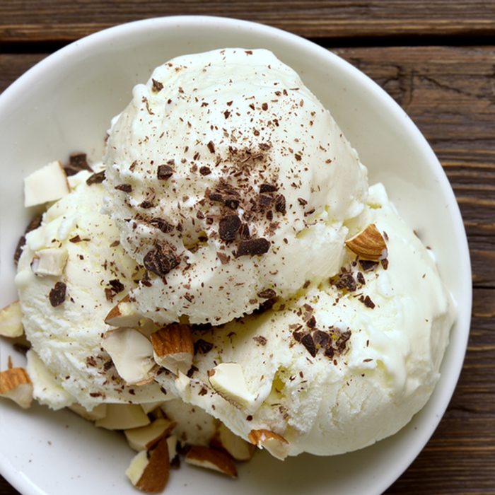 Close up of ice cream with nuts on wooden background with copy space. Top view, flat lay; Shutterstock ID 1111741730; Job (TFH, TOH, RD, BNB, CWM, CM): Taste of Home