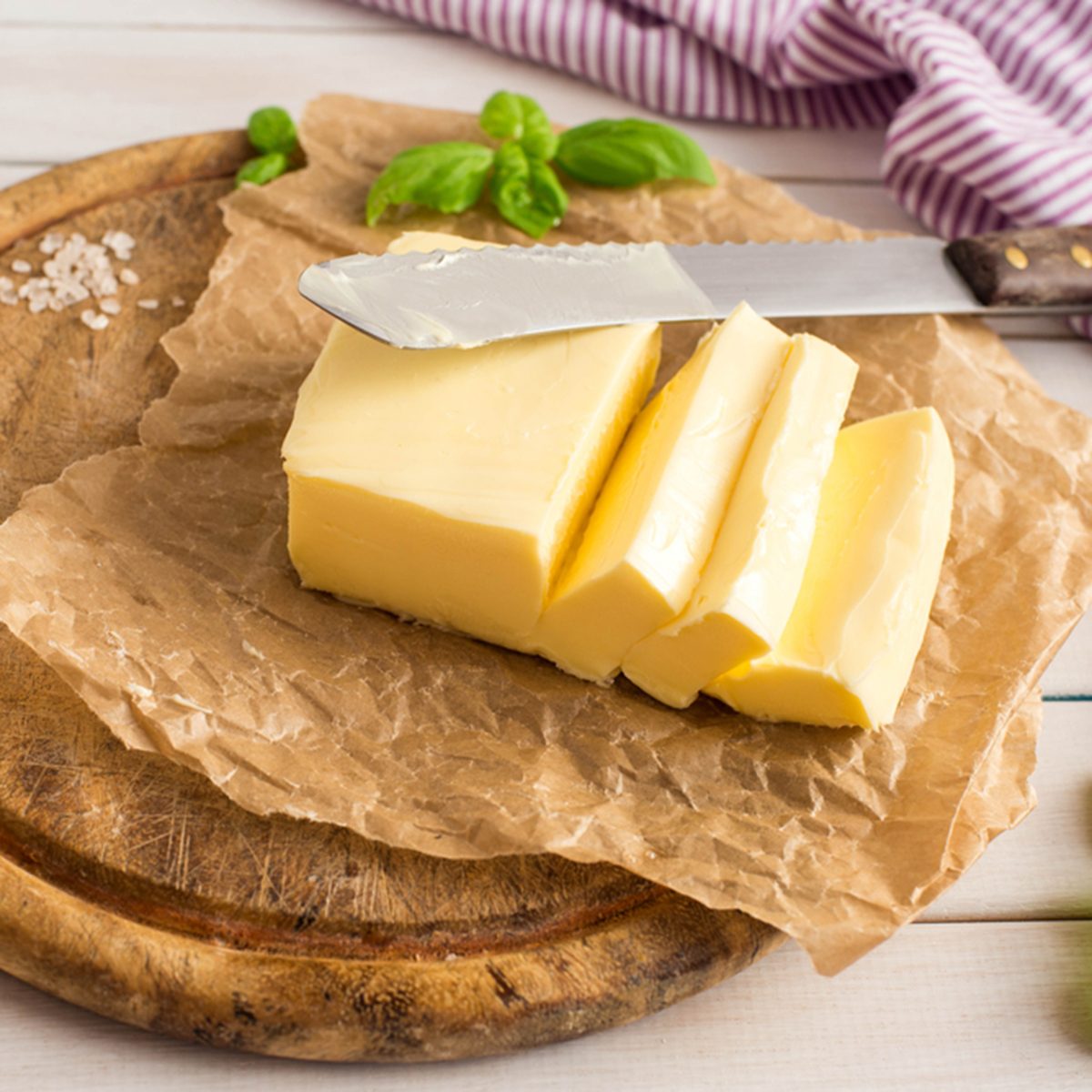 Slice of butter. Fresh sliced butter on the wooden plate.