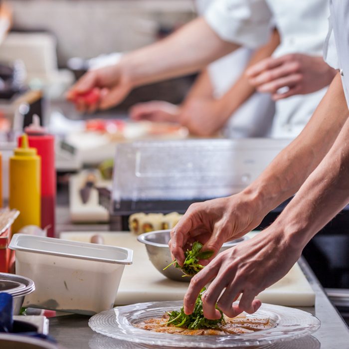 male cooks preparing meals in restaurant kitchen