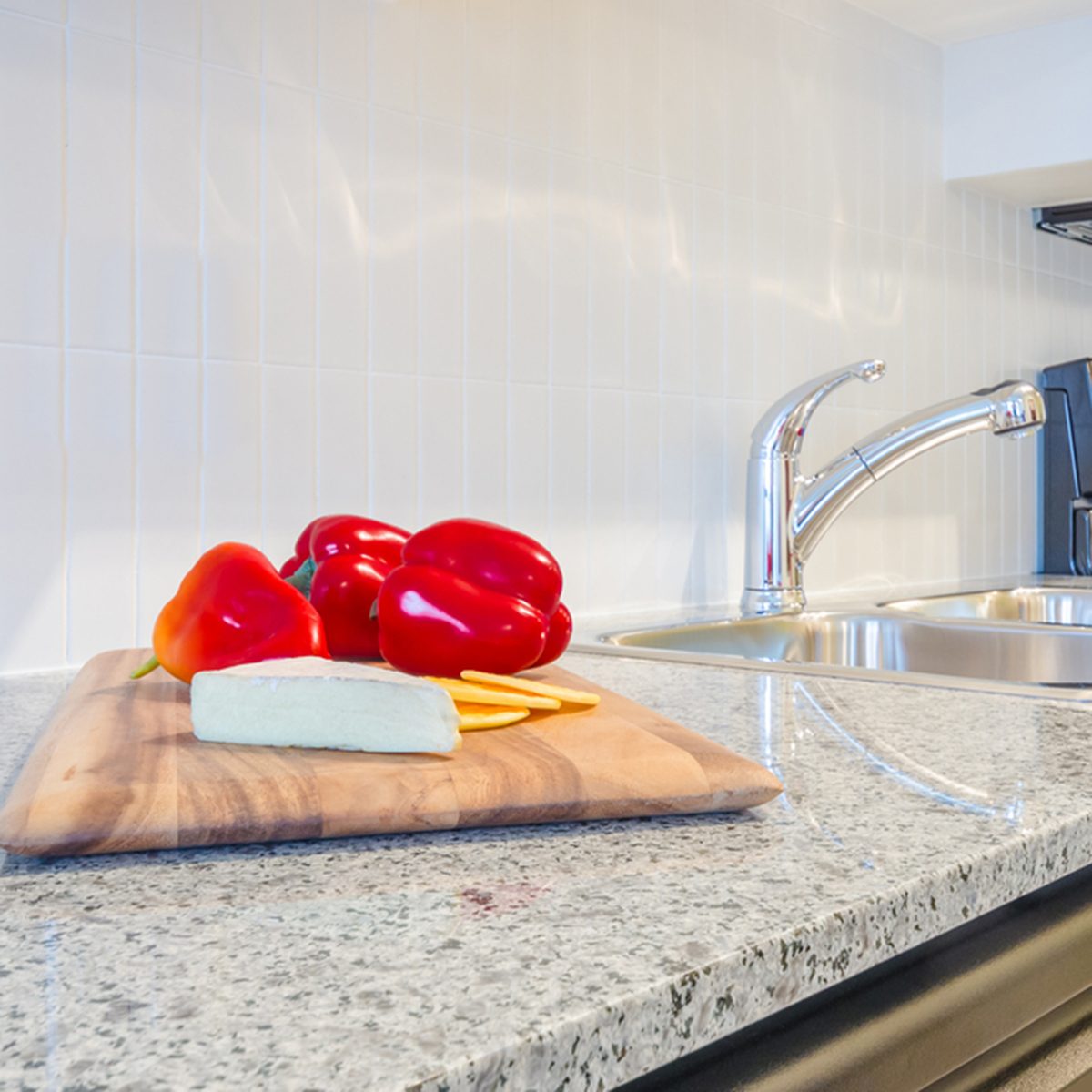 interior of small white kitchen with red pepper on the table