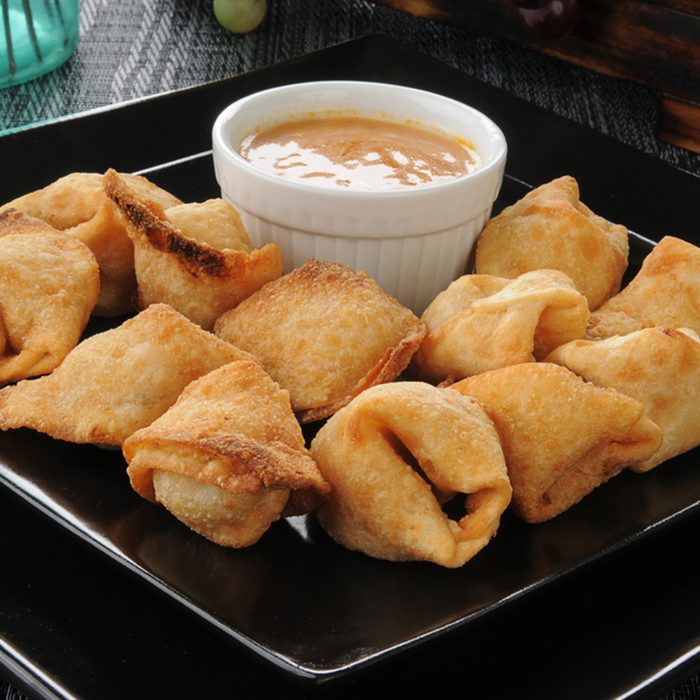 Close of up crab rangoon with peanut sauce