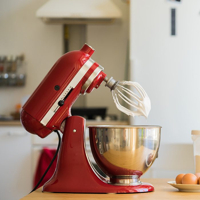 red stand mixer mixing cream
