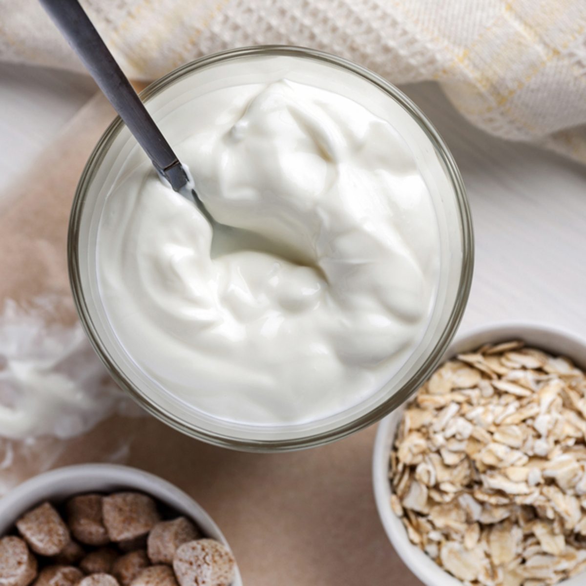 Yogurt with wheat bran and oat flakes on a wooden table
