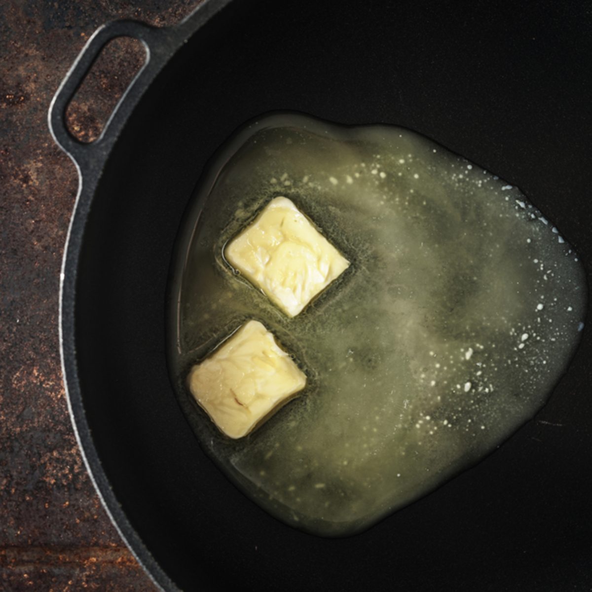 Pieces of butter in the hot pan top view