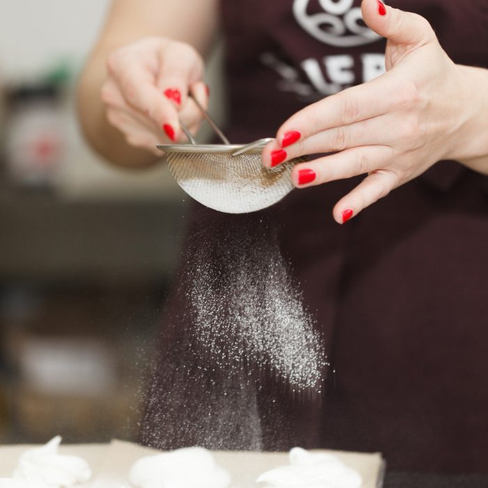Confectioner sprinkles powdered sugar on marshmallow