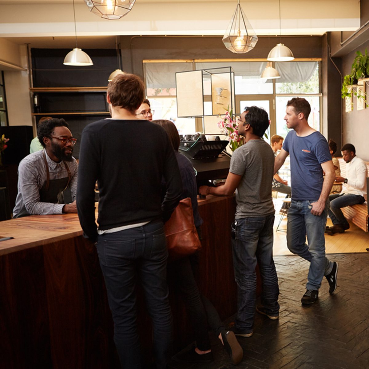 People standing at the counter of a modern coffee shop