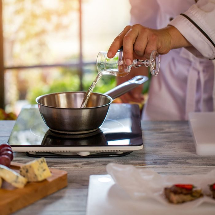 Glass pouring liquid on saucepan.