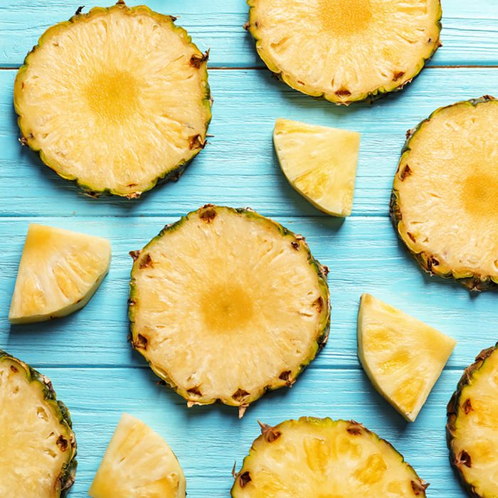 Flat lay composition with fresh sliced pineapple on wooden background;