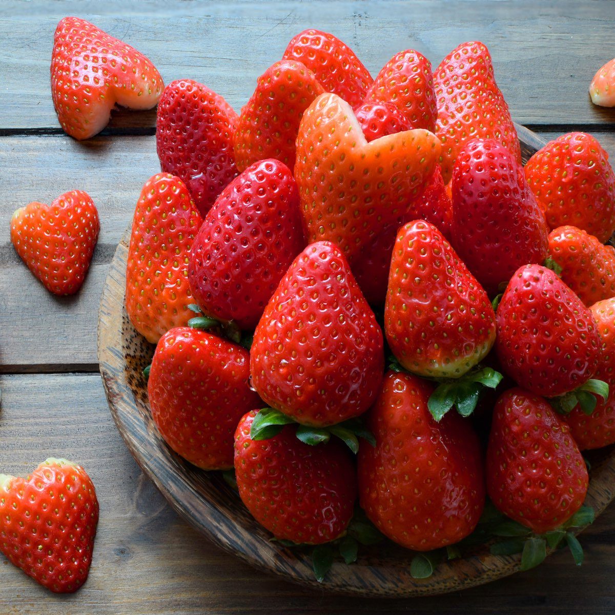 Fresh Strawberry and strawberry heart in wooden plate on wooden 