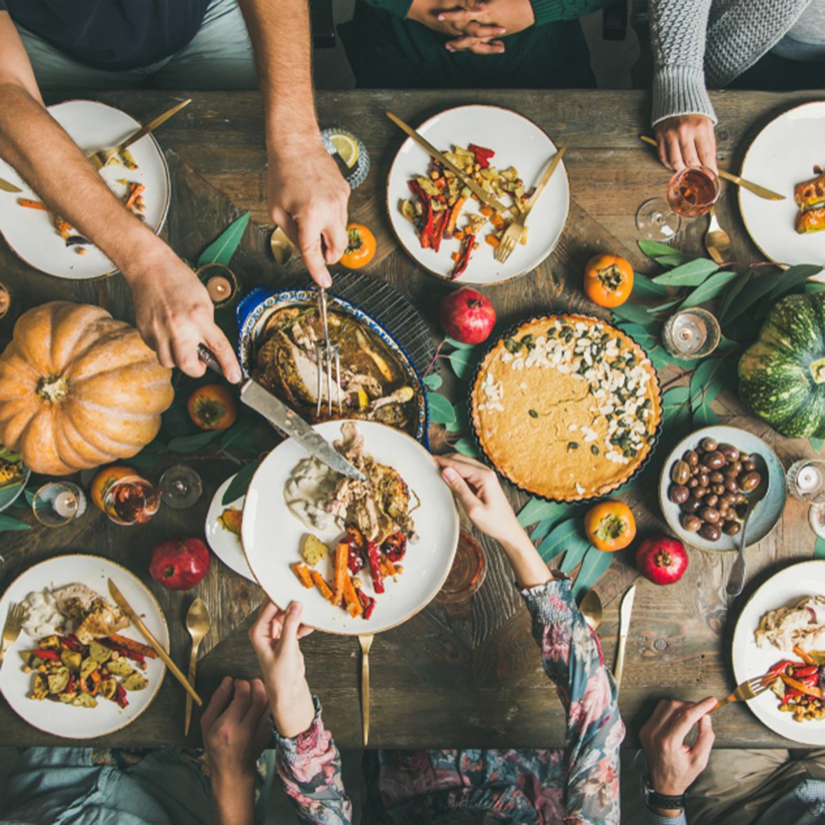 Traditional Thanksgiving day celebration party. Flat-lay of Friends or family eating different snacks and roast turkey or chicken at Festive Christmas table, top view; Shutterstock ID 1220868844; Job (TFH, TOH, RD, BNB, CWM, CM): TOH