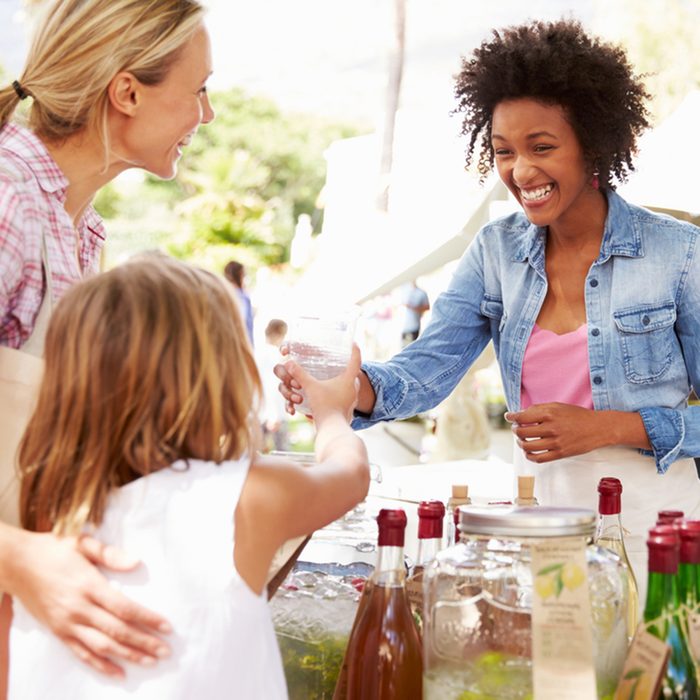 Woman Selling Soft Drinks At Farmers Market Stall