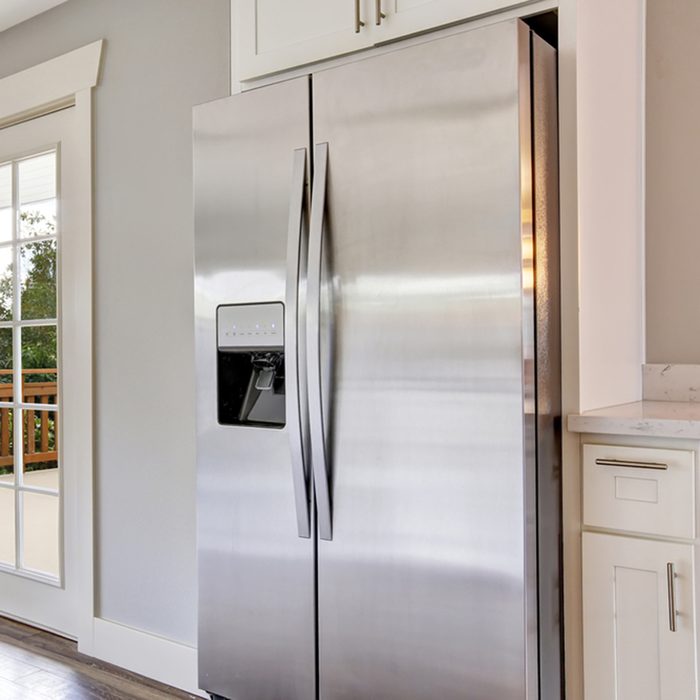 Bright kitchen room with steel appliances and granite tops.