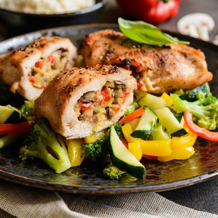 Roasted chicken breasts stuffed with mushrooms, green onion, pepper and sheep cheese, garnished with steamed vegetable and rice