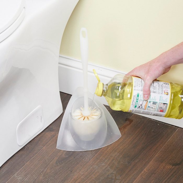 Pouring soap on a toilet brush