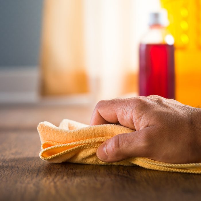 Male hand applying wood care products and cleaners on hardwood floor surface.; Shutterstock ID 221628484