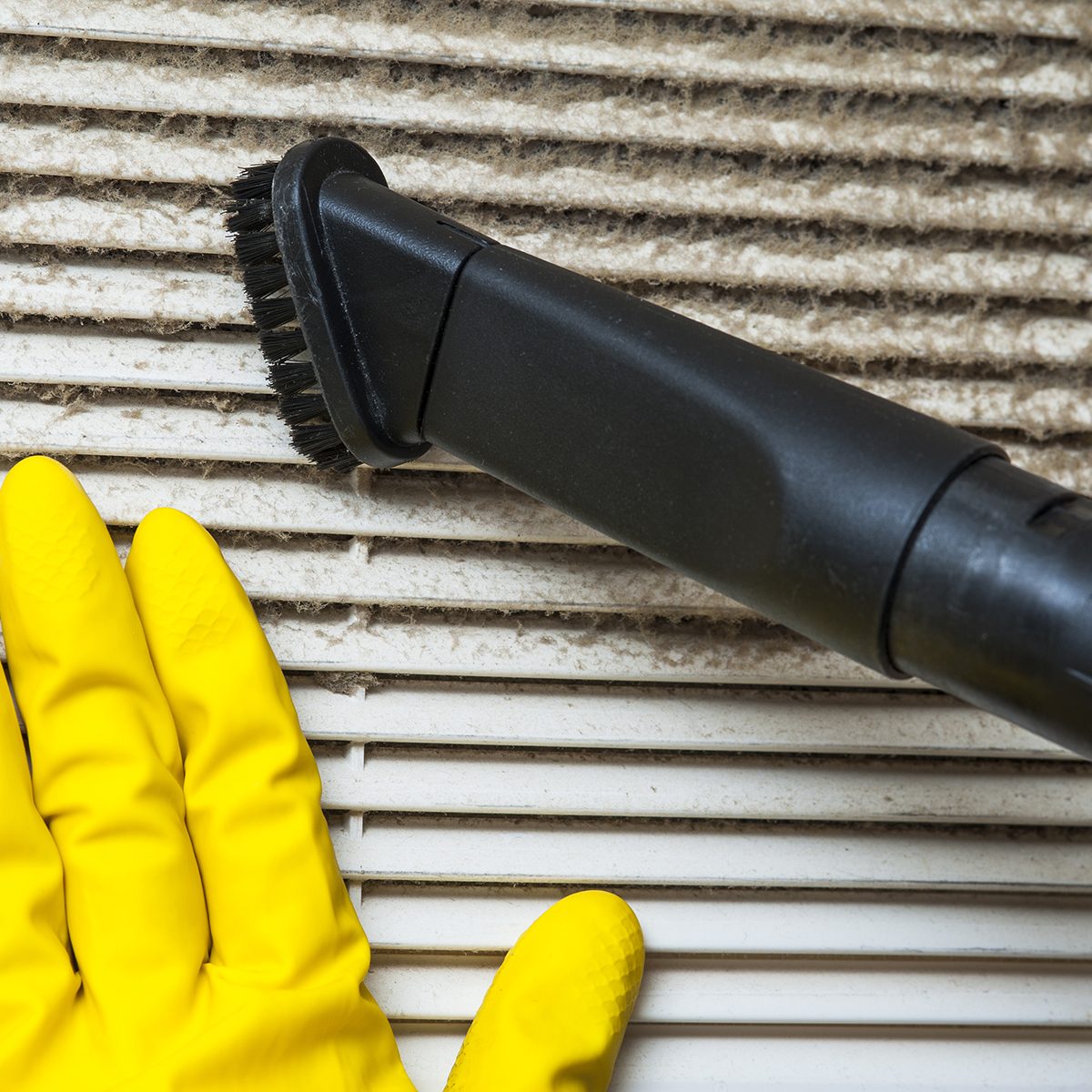 Hand in yellow glove and vacuum cleaner pipe. Ventilation grill cleaning.; Shutterstock ID 389950375; Job (TFH, TOH, RD, BNB, CWM, CM): TOH