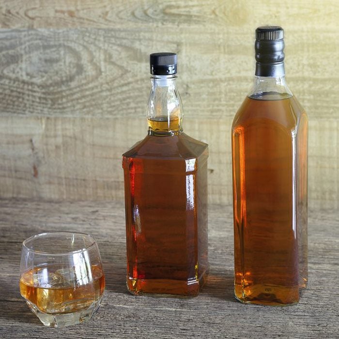 Bottles of apple cider vinegar and some in a small cup