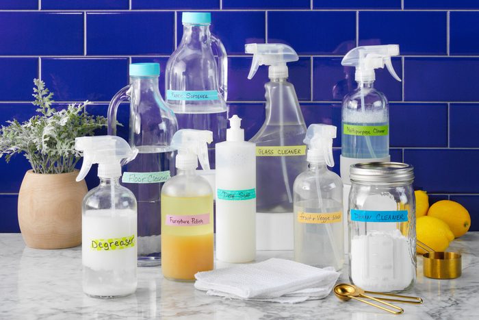 Homemade Cleaners collection of bottles arranged on a countertop with blue tile back splash