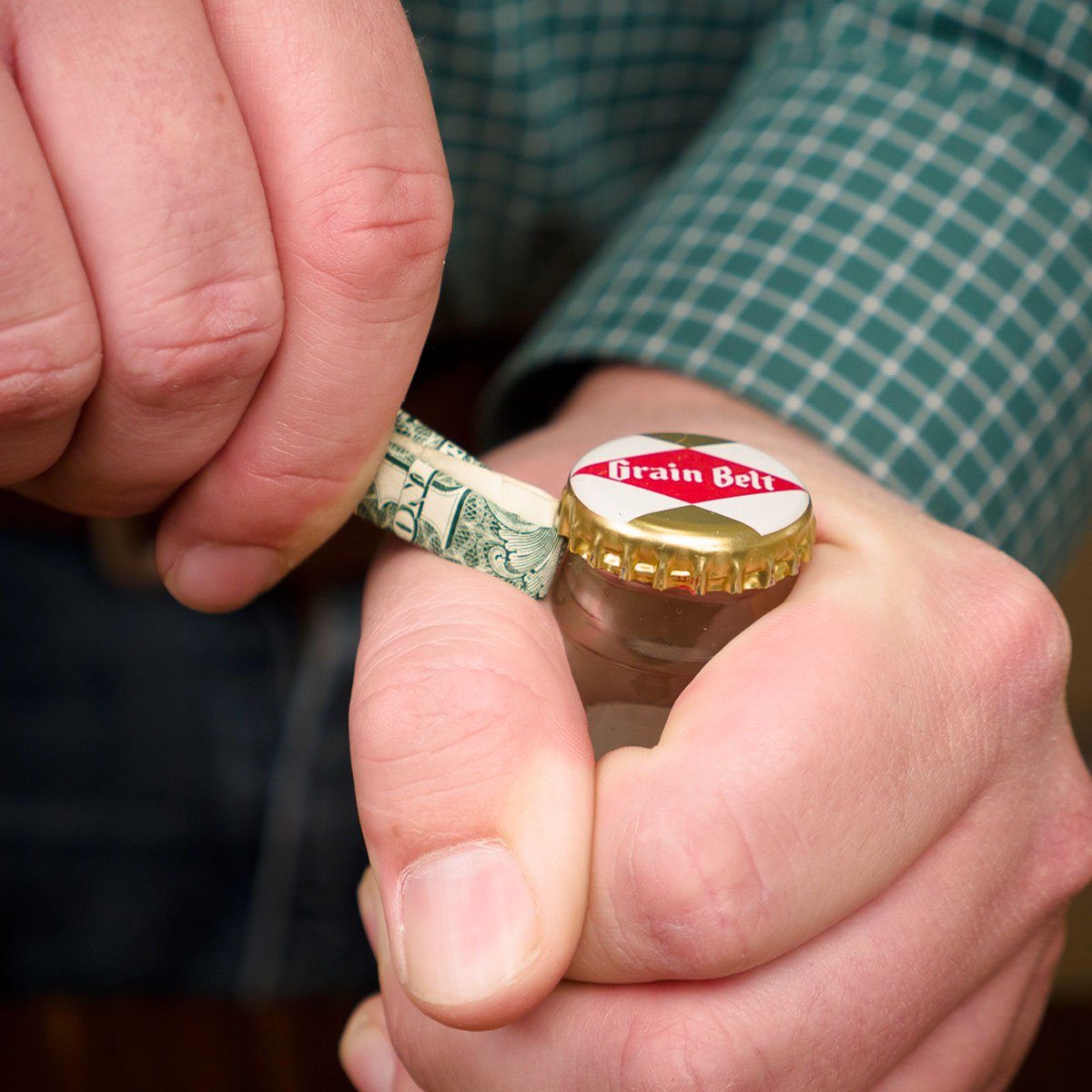 Opening bottle with rolled up dollar bill
