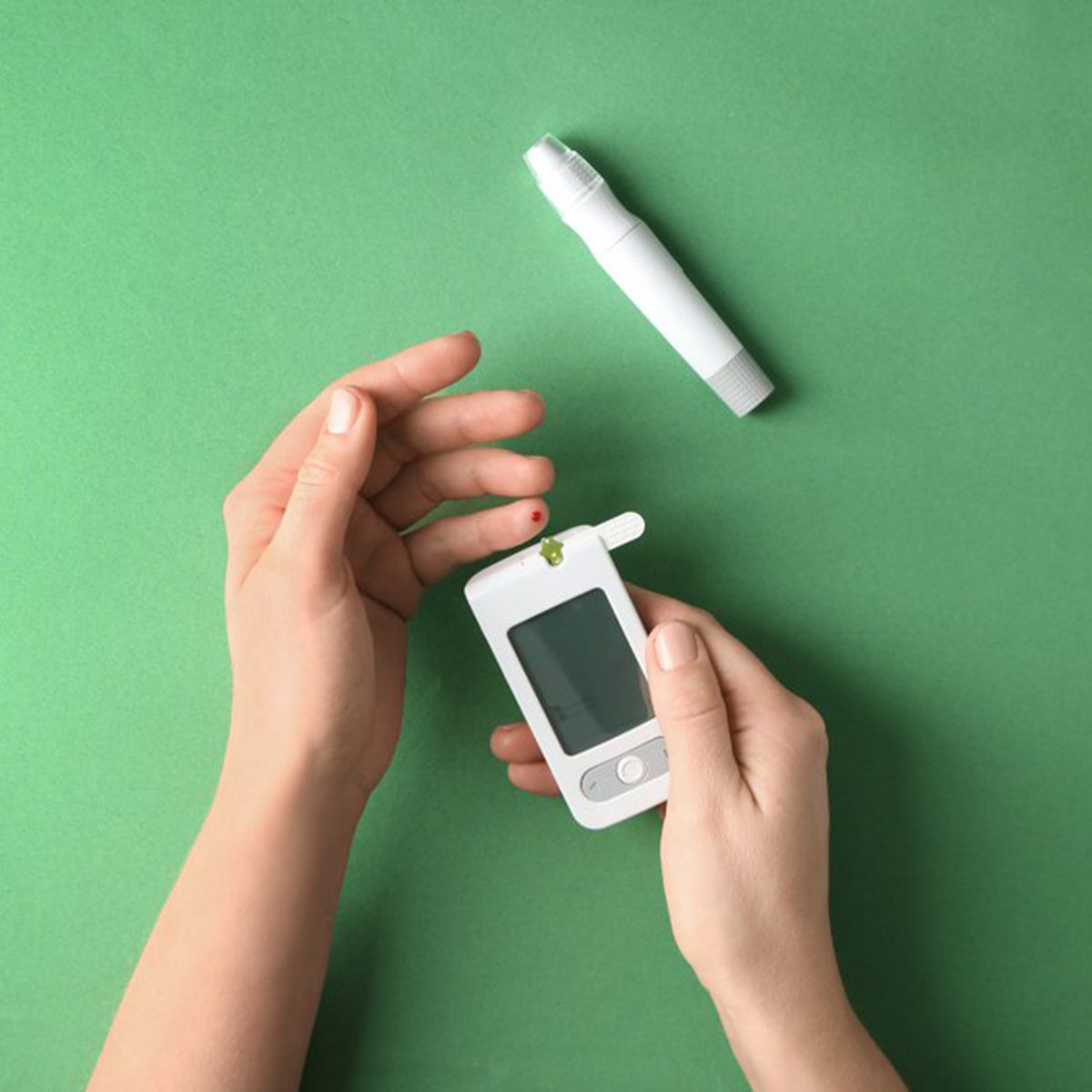 Someone testing their blood in a handheld machine