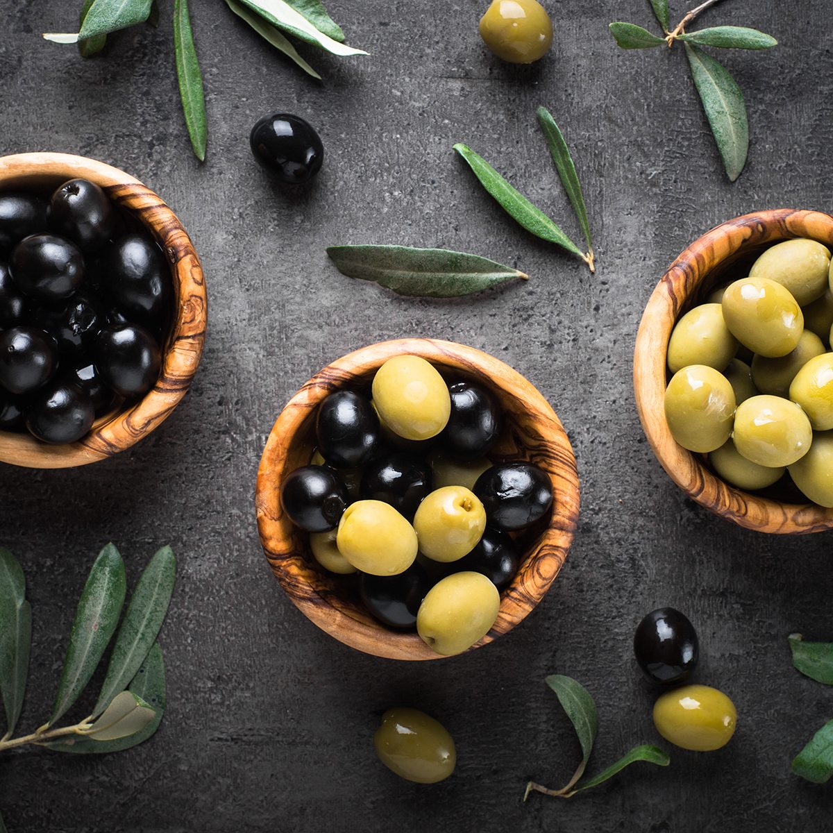 Black and green olives in wooden bowls.